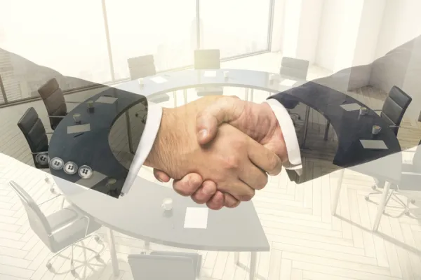 Double exposure handshake of two businessmen on conference room interior background, collaboration and cooperation concept