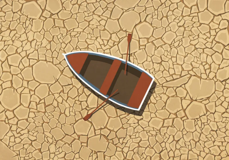 Abandoned rowboat stranded on dry, cracked land